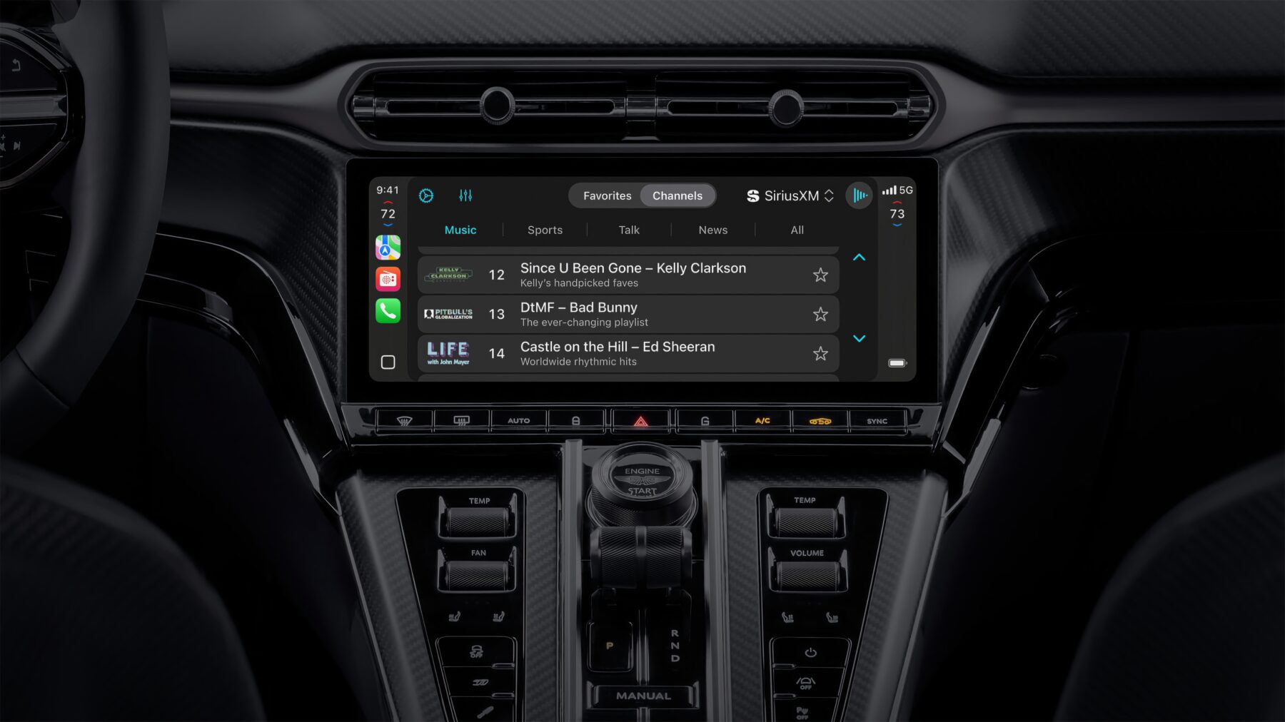 Mittelkonsole eines Autos mit großem Touchscreen-Display, das die SiriusXM-Musik-App zeigt. Darauf sind Musiktitel von Kelly Clarkson, Bad Bunny und Ed Sheeran zu sehen. Unter dem Bildschirm befinden sich Bedienelemente für Klima und Sitzheizung sowie ein Drehknopf mit der Aufschrift „Engine Start“. Die Oberfläche hat eine Carbon-Optik.